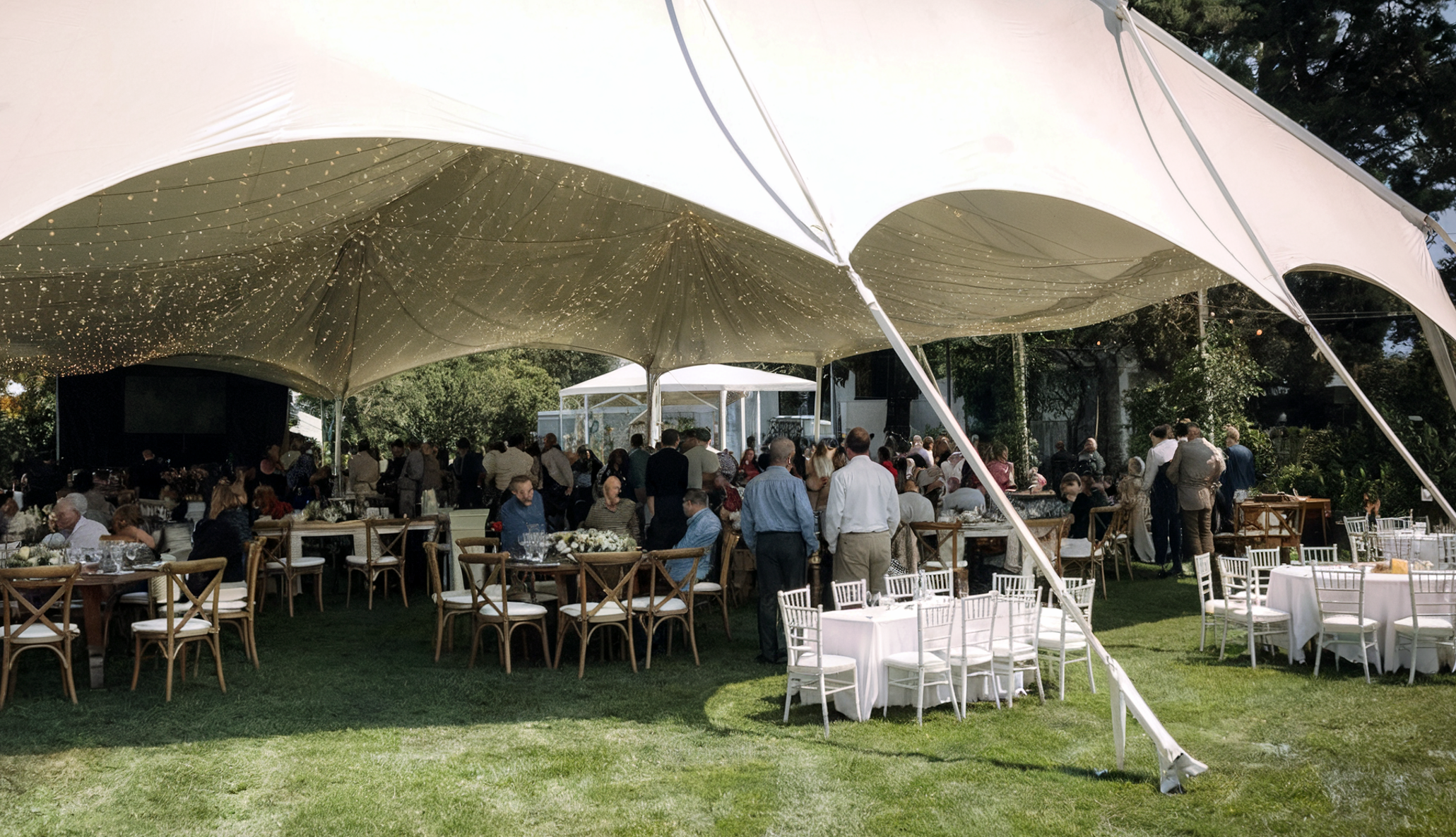 A daytime outdoor event setup with a large white...